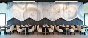 a dining room with tables and chairs and a large chandelier at Euphoria Club Hotel in Borovets