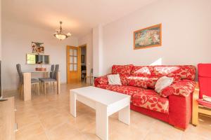 sala de estar con sofá rojo y mesa en Paraiso Costero - Adults Only - en Conil de la Frontera