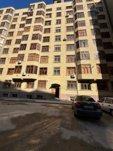 een groot gebouw met een auto voor de deur bij Уютная квартира в центре города in Samarkand