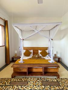 a bedroom with a bed with a canopy at Kholle Villa in Jambiani