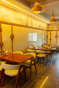 a restaurant with wooden tables and yellow chairs at PVR Suites off Bannerghatta Road in Bangalore