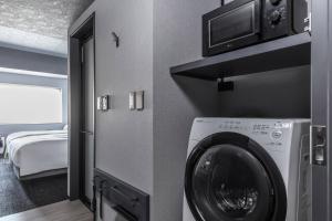 uma máquina de lavar e secar roupa numa sala com um quarto em Mercure Tokyu Stay Osaka Namba em Osaka