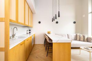 a kitchen and a living room with a couch at Vanagupes Park Apartment, By Cohost in Palanga