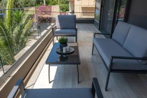 uma varanda com 2 cadeiras azuis e uma mesa em Greyt Apartments Glyfada em Atenas