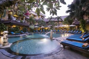a swimming pool at a hotel with chairs and umbrellas at Parigata Resorts and Spa in Sanur