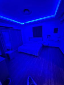 um quarto com uma cama e uma luz azul em استراحة رفييف em Khalij Salman