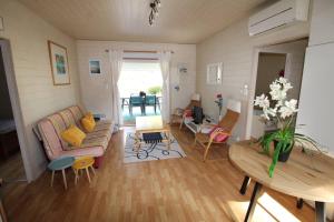 ein Wohnzimmer mit einem Sofa und einem Tisch in der Unterkunft GASMIM29 - Golfe de St-Tropez, chalet climatisé dans domaine arboré in Gassin