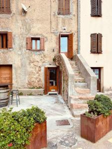 un edificio antiguo con una escalera que conduce a una puerta en Charmant petit appartement place de l eglise, en Piana