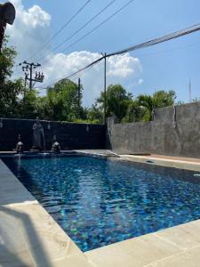 a swimming pool with blue water in a yard at Urbanview Ava Guest House Goa Gong in Jimbaran