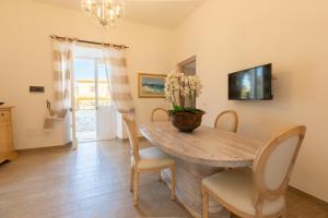 uma sala de jantar com uma mesa de madeira e cadeiras em Stazzo San Teodoro em San Teodoro