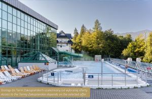 uma piscina com escorrega em frente a um edifício em Hotel Aquarion Family & Friends em Zakopane