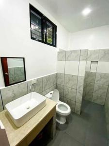 een badkamer met een wastafel en een toilet bij Kakisa ll Diving Resort in Bacong