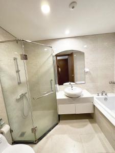 La salle de bains est pourvue d'une douche, d'un lavabo et de toilettes. dans l'établissement Vinhomes Times City 3BR, à Hanoï