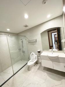 La salle de bains est pourvue de toilettes, d'un lavabo et d'une douche. dans l'établissement Vinhomes Times City 3BR, à Hanoï