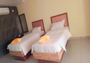 two twin beds sitting next to each other in a room at Urban Lounge in Rājahmundry