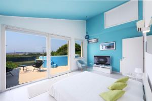 a bedroom with a bed and a large window at Salicornia - Sea view villa with pool in Marsala
