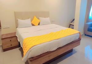ein Schlafzimmer mit einem großen Bett mit gelber Bettwäsche in der Unterkunft Urban Lounge in Rājahmundry