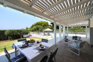 a patio with a table and chairs and a pool at Salicornia - Sea view villa with pool in Marsala