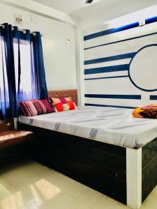 a large bed in a room with blue and white stripes at Shree Hotels in Bhāgalpur