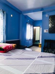 バーガルプルにあるShree Hotelsの青い壁のベッドルーム1室(大型ベッド1台付)