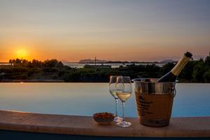 a bottle of wine and a glass next to a pool at Salicornia - Sea view villa with pool in Marsala +45 photos