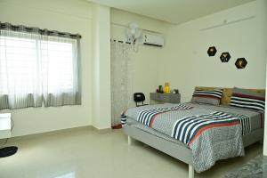 Habitación blanca con cama y ventana en Rent on comfort Vijaynagar en Mysore