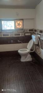 La salle de bains est pourvue de toilettes et d'une fenêtre. dans l'établissement Saumya Home Stay, à Munsyari