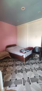 - une chambre avec un lit et une chaise dans l'établissement Saumya Home Stay, à Munsyari