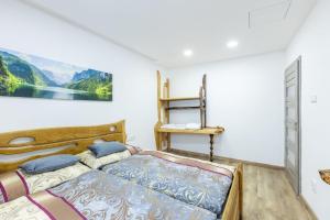 a bedroom with two beds and a painting on the wall at Chalety Bystra in Horná Lehota