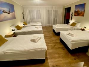 a group of four beds in a room at Yose Apartment in Poznań