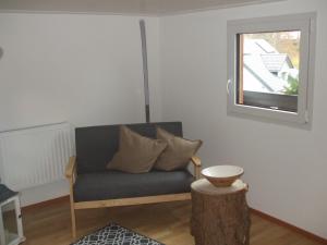 a living room with a blue couch and a window at Haus Winterberg in Schonach