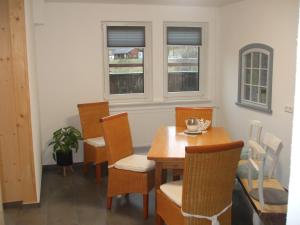 uma sala de jantar com uma mesa e cadeiras e duas janelas em Haus Winterberg em Schonach