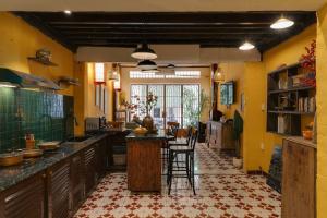uma cozinha com paredes amarelas e uma mesa e cadeiras em Ben Thanh Vietnamese cultural house by SSens Homes em Ho Chi Minh