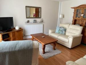 a living room with a couch and a coffee table at 32 Maescurig in Newport