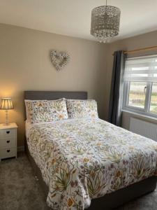 a bedroom with a bed and a window with a heart on the wall at 32 Maescurig in Newport Pembrokeshire