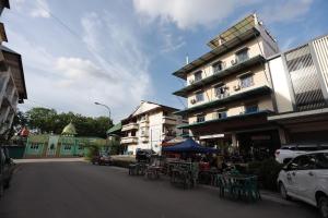 a building with tables and chairs on a city street at OYO 93671 Sir Homestay in Nagoya