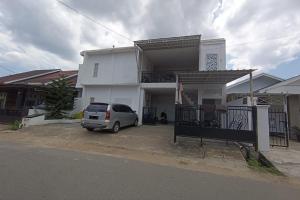 a van parked in front of a white building at OYO 93654 Gr Kost Kaladan in Rantau