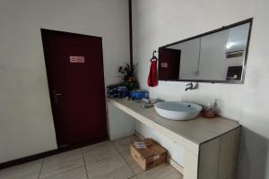 a bathroom with a sink and a mirror at OYO 93654 Gr Kost Kaladan in Rantau