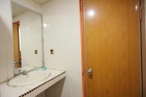 a bathroom with a sink and a mirror at OYO 93671 Sir Homestay in Nagoya