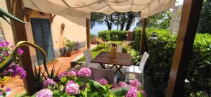 um pátio com uma mesa, cadeiras e flores em Casa Vacanze Luna em Portovenere
