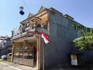 an old building with a flag on a balcony at SPOT ON 93670 Homestay Vicky 2 Syariah in Sidoarjo