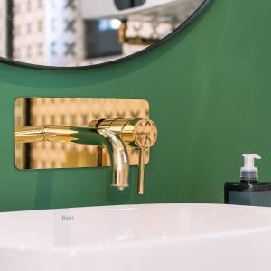 a bathroom sink with a gold faucet and a mirror at the BOX BNB in Wilton