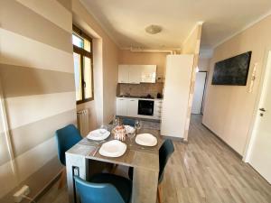 a dining room with a table and chairs and a kitchen at L'ETERNITA' E' IL MARE MISCHIATO COL SOLE Rimbaud in Ventimiglia