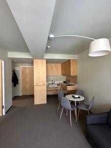 a living room with a table and chairs and a kitchen at Bakuriani Kokhta Apartments in Bakuriani