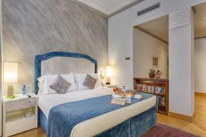 Schlafzimmer mit einem großen Bett mit blauem Kopfteil in der Unterkunft Rivoli Boutique Hotel in Florenz