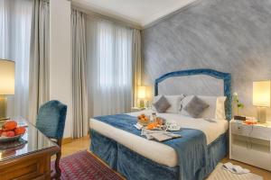 a hotel room with a bed with a tray of fruit on it at Rivoli Boutique Hotel in Florence