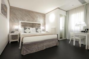 una camera con un grande letto e una scrivania di Rivoli Boutique Hotel a Firenze
