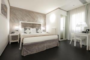 1 dormitorio con 1 cama grande y escritorio en Rivoli Boutique Hotel, en Florencia