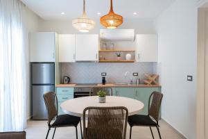 a kitchen with a table and chairs and white cabinets at Kondias Experience in Kondiás +16 photos