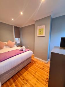 a bedroom with a bed and a flat screen tv at Stylish 3 Bedroom Galway House in Galway